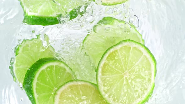 Super Slow Motion Shot of Lime Slices Falling Into Water Whirl at 1000 Fps