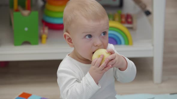 Kid Eats an Apple Sitting on the Floor and Watching Tv