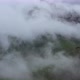 Drone Flight above green fields at the mountains in the clouds and fog. - VideoHive Item for Sale