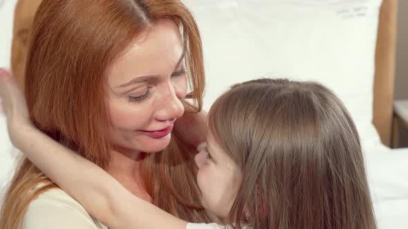 Happy Mother Hugging Her Little Daughter Hugging, Smiling To the Camera