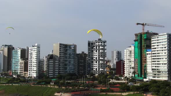 4k aerial video of paragliders flying incredibly close to the coastline of Miraflores in Lima, Peru.