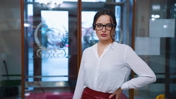 Serious young woman entered a hotel and looks for reception.