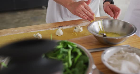 Caucasian female chef teaching diverse group preparing dishes and smiling