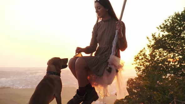 Pretty Young Girl on a Swing During Amazing Sunset