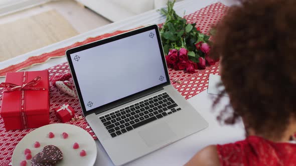 Mixed race woman on a valentines date video call using laptop computer