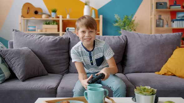 Portrait of Happy Boy Playing Videogame Alone Sitting on Comfortable Couch at Home