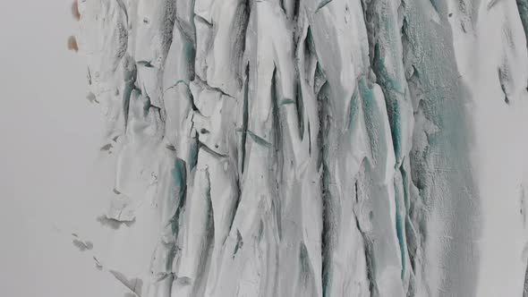 Stunning cenital aerial drone shot above glacier in iceland. White frozen huge natural texture forma