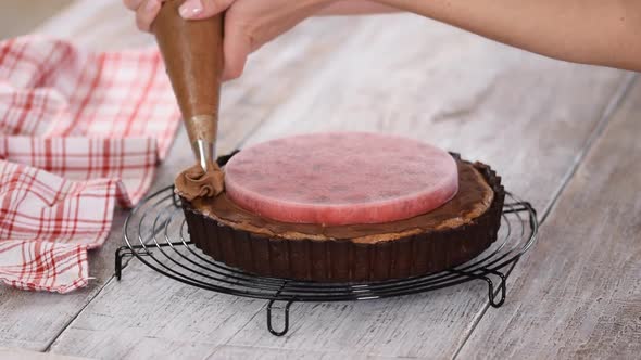 Confectioner Decorates Delicious Chocolate Tart with Cherry Confit and Chocolate Cream.