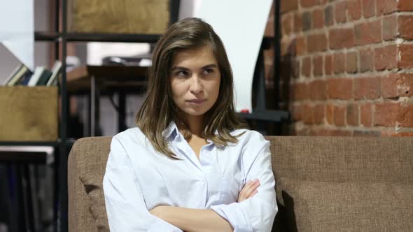 Frustrated Upset Girl Sitting on Sofa in Loft Office
