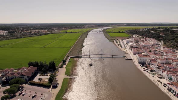 Rio Sado along Alcacer do Sal riverside and green agricultural fields. Aerial view