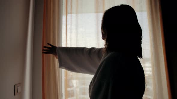 Woman in Hotel Room Opens Curtains and Walks Balcony Beautiful City View