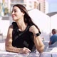 Cheerful Woman Sitting at Outdoor Cafe Table - VideoHive Item for Sale