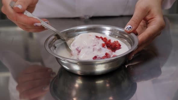 Close-up of a Girl Mixing Fresh Strawberries with Yogurt in a Bowl.