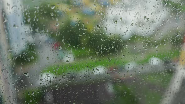 Raindrops run down the window pane on a rainy day alt