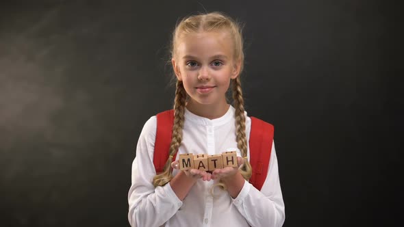 Math Word on Wooden Cubes in Schoolgirl Hands