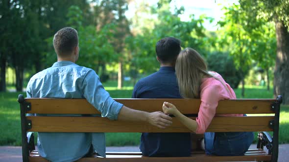 Couple Hugging on Bench, Girl Secretly Holding Hands With Another Man, Betrayal