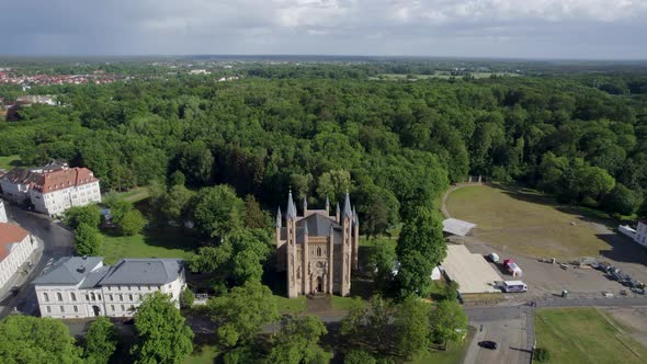 Drone shot of Schlosskirche church in green forest in Neustrelitz, Germany.