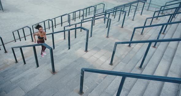 Sportive Black Woman Runs Up Stairs with Railings on Street