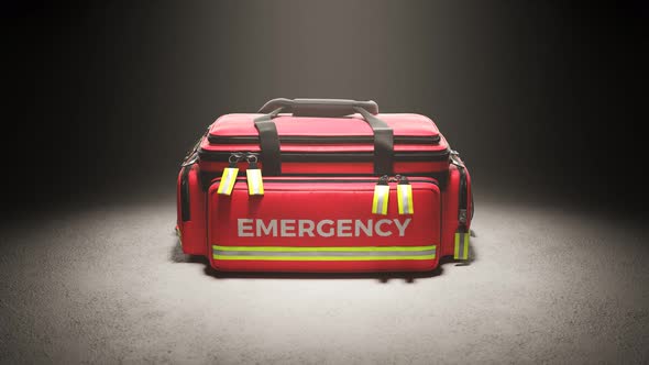 The red emergency first aid bag in the studio spotlight. Paramedic kit. 4KHD