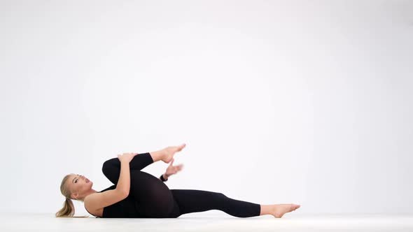 Sexy girl doing fitness exercises. Shooting in the studio on a white background