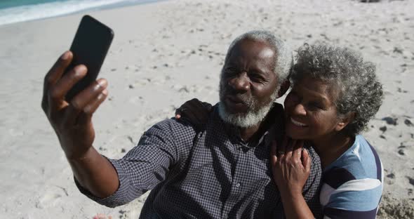 Senior couple taking photos at the beach