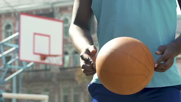Professional Basketball Player Holding Ball, Encouraging Young People for Sports