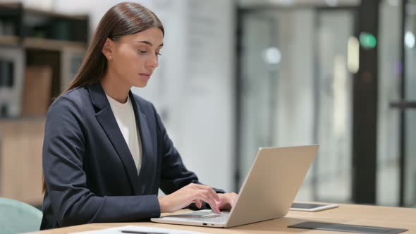 Serious Businesswoman with Laptop Looking at the Camera