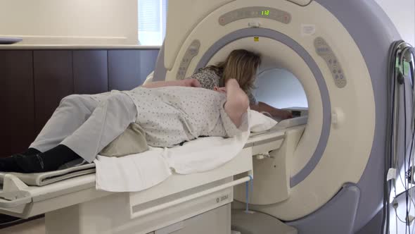 Nurse position man into MRI.