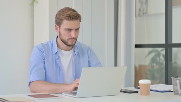 Young Creative Man Working on Laptop in Office