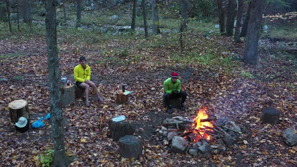 Two men sit by campfire - Forest - Autumn