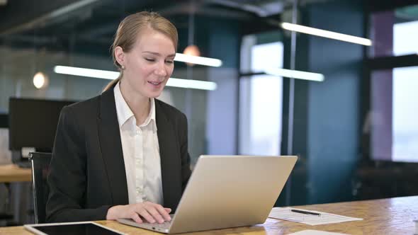 Cheerful Young Businesswoman Doing Video Chat on Laptop