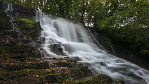 Time lapse of forest waterfall in rural landscape during autumn in Ireland. alt