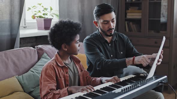 Music Teacher Showing Notes to Boy