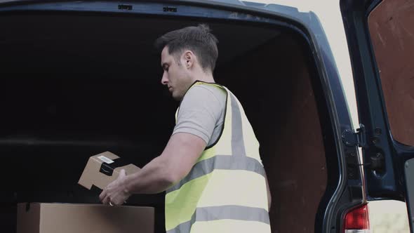 Delivery man scanning boxes with barcode scanner