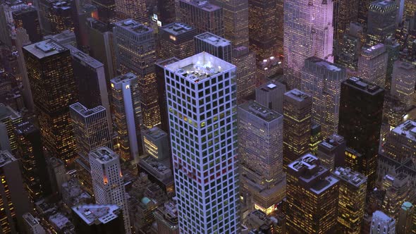 Helicopter Aerial Shot of Modern Skyscraper Buildings in Urban City Metropolis at Night