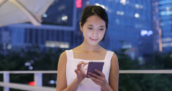 Woman use of cellphone in the city in the evening