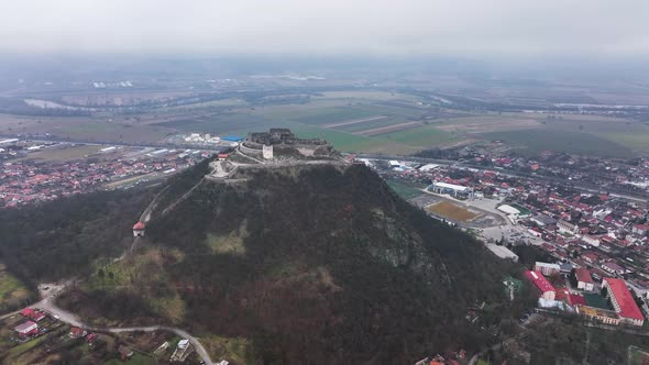 Stunning Aerial View of the Medieval Stone Fortress of Deva on a Cloudy Day