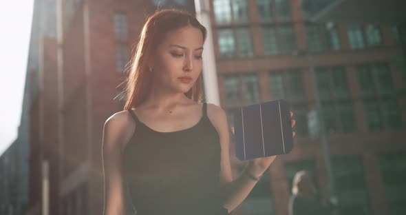 Young woman looking at the solar cell she is holding