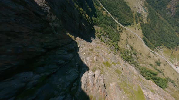 FPV Sports Drone Dive From Rocky Mountain Texture Over Picturesque Hilly Sunny Valley Landscape