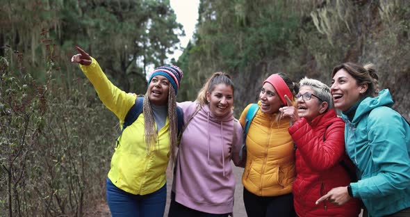 Multiracial women having fun during trekking day in to the wood