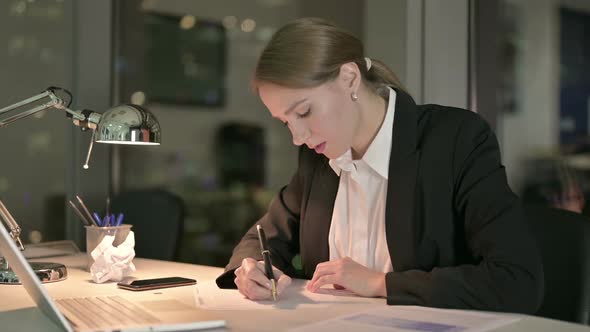 Beautiful Businesswoman Thinking and Working on Document at Night