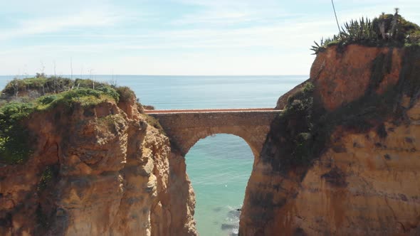 Estudante Beach Roman bridge joining eroded cliffs in Lagos, Algarve, Portugal