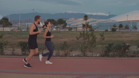 Two Happy People Are Jogging on Fresh Air in Evening, Male and Female Runners