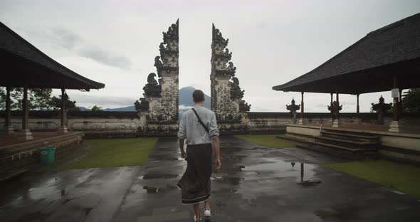 Dolly Shot Following a White Male Tourist Walking Towards a Famous Black Stone Pillars in Pura