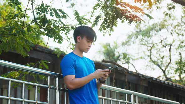 Athletic man using his smartphone checking social media and texting on his smartphone.