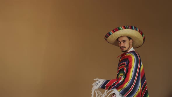 Young Mexican In Multicolored Poncho And Hat