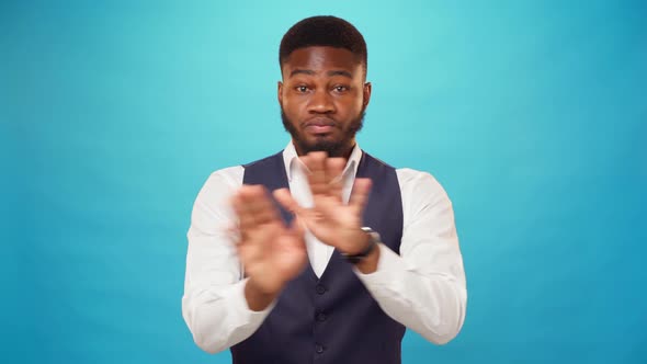 Young African American Guy Rejects Something with Crossed Hands Says 'No' Blue Background