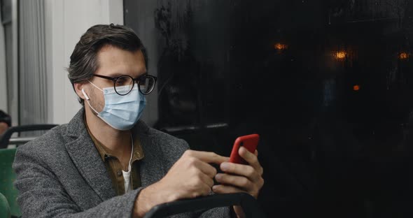 Crop View of Male Person in Protective Mask and Glasses Using Smartphone