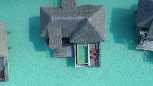 Aerial drone view of a luxury resort and overwater bungalows in Bora Bora tropical island.