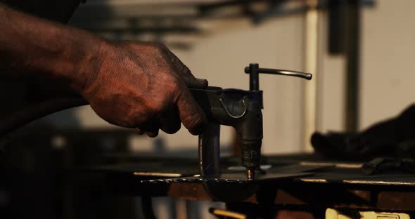 Hands of welder using welding torch